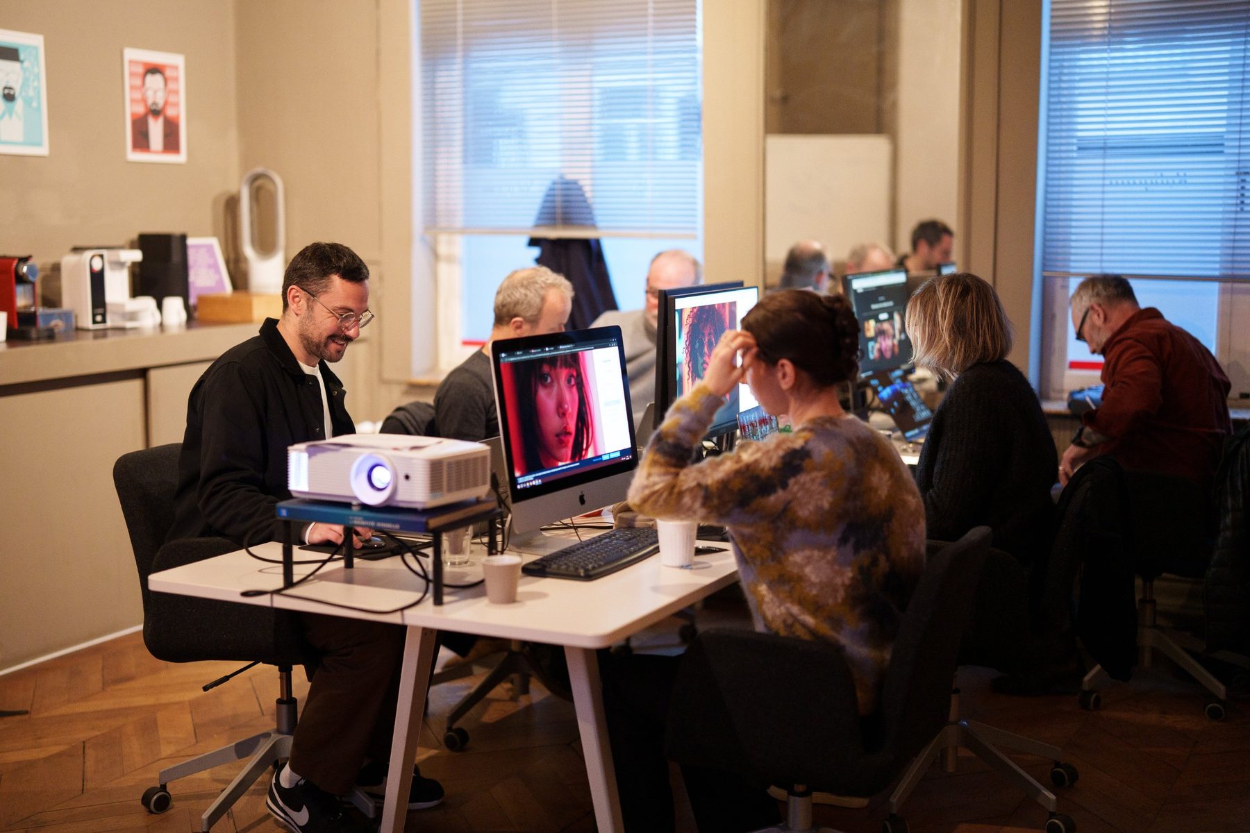 Des stagiaires en formation IA graphique chez Kaligram, dans le Vieux-Lille, devant des images générées par IA