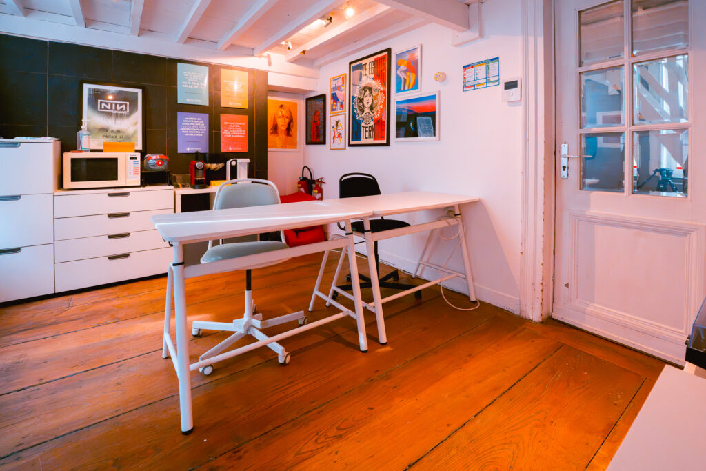 La petite salle de formation Kaligram pour le 1-to-1 : deux postes de travail, parquet et affiches colorées